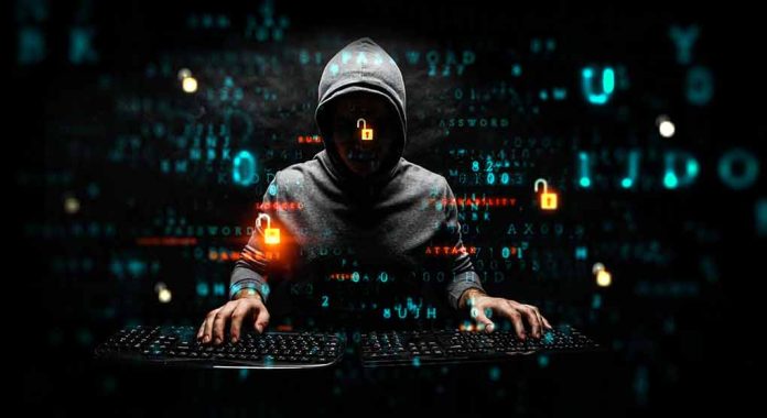 Hacker in hoodie using computer with digital code background.