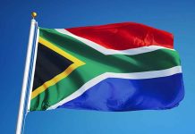 South African flag waving against blue sky.