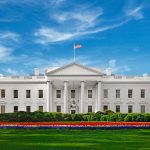 White House with American flag under blue sky