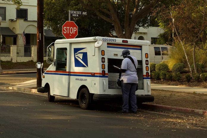 USPS mail carrier at truck near stop sign.