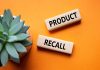 "Product recall" sign near succulent on orange background.