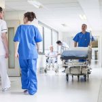 Doctors and nurses in hospital corridor with stretcher