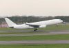 White airplane taking off from a runway.