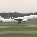 White airplane taking off from a runway.