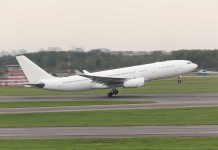 White airplane taking off from a runway.