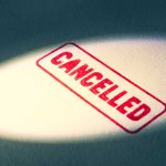 Red Cancelled stamp under a spotlight.