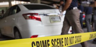 Crime scene with yellow tape and parked car