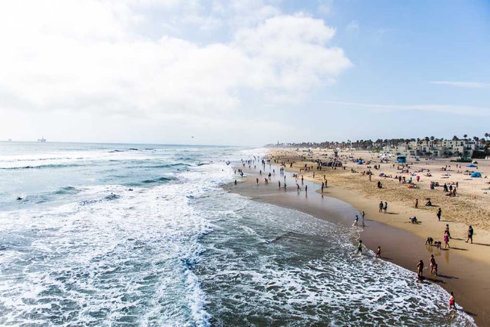 697274677 featured image Crowded beach with waves and people enjoying sun.