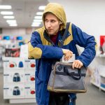 Person in store, hiding something in a bag