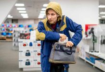 Person in store, hiding something in a bag