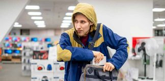 Person in store, hiding something in a bag