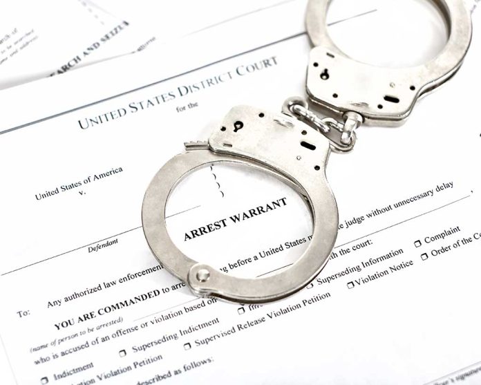 1316784506 featured image Handcuffs on top of arrest warrant document