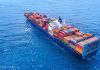 Cargo ship carrying colorful containers in open sea.