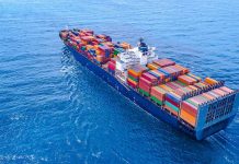 Cargo ship carrying colorful containers in open sea.