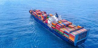 Cargo ship carrying colorful containers in open sea.