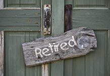Rustic retired sign on green wooden door