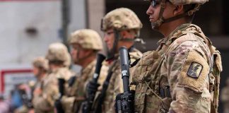 Soldiers in camouflage standing in a line with rifles