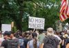 Crowd holds No More Mandates sign at protest