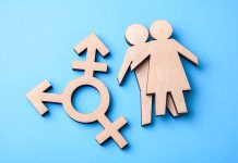 Wooden transgender symbol and couple figures on blue background