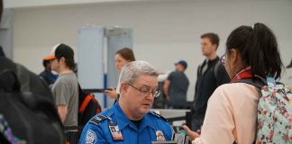 TSA agent checks passenger's documents at airport security