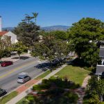 Street with church, parked cars, and trees