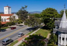 Street with church, parked cars, and trees