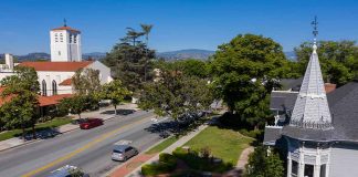 Street with church, parked cars, and trees
