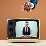 Hand controlling puppet strings on TV broadcast