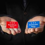 Hands holding Republican and Democratic Party cards