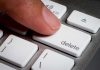 Finger pressing a delete key on keyboard