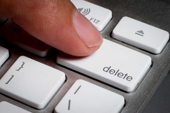 Finger pressing a delete key on keyboard