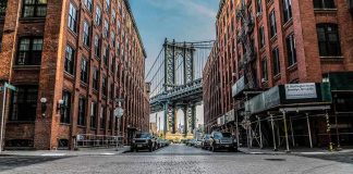 Street view with bridge between two brick buildings