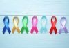 Colorful awareness ribbons on light wooden background