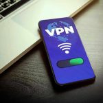 Smartphone displaying VPN app beside a laptop