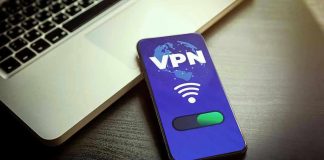 Smartphone displaying VPN app beside a laptop