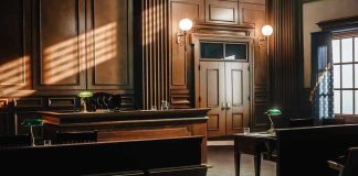 Empty courtroom with wooden interior and green lamps