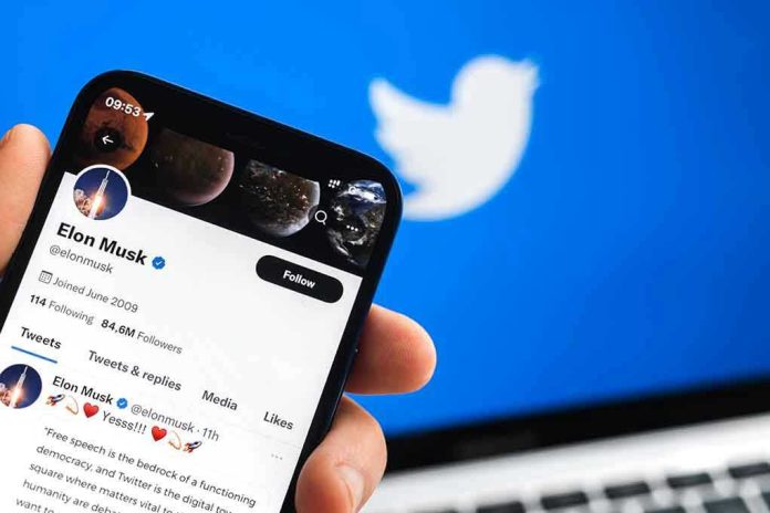 2150043711 Hand holding phone displaying Twitter profile