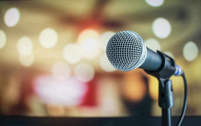676019521 Microphone with blurred lights in the background