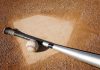 A baseball bat and ball resting on a baseball diamond