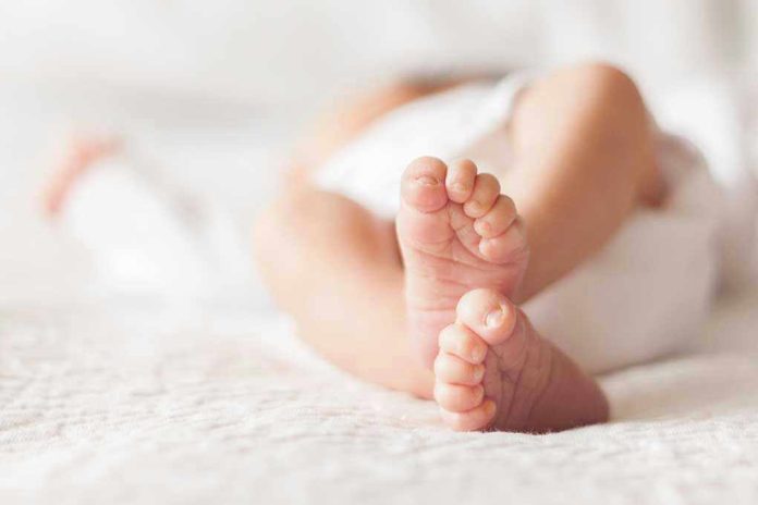 1111986902 Close up of baby feet lying on blanket