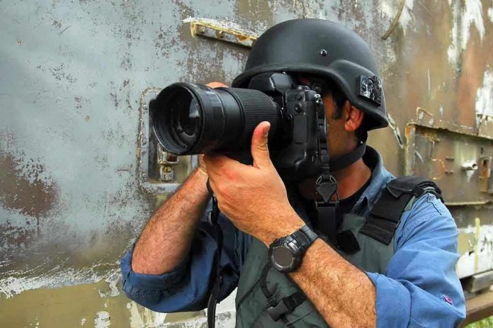Person in helmet taking photos with a large camera.