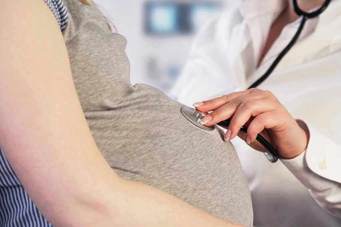 261991445 Doctor uses stethoscope on pregnant woman's belly