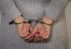 Person in handcuffs with gray sweater.