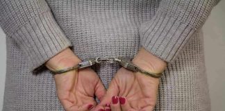 Person in handcuffs with gray sweater.