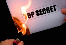 A hand holding a lighter igniting a paper labeled 'TOP SECRET' as it catches fire