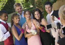 Group of friends in formal attire posing for a photo during prom night