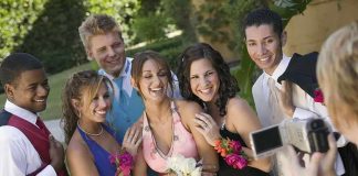 Group of friends in formal attire posing for a photo during prom night