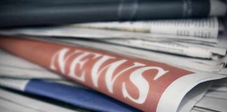 Stack of newspapers with NEWS headline visible.