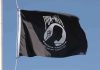 POW MIA flag waving against a blue sky