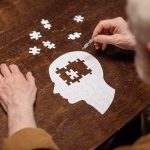 Exploring the Connection: Can SSRIs Influence Dementia Progression? Elderly person completing head-shaped jigsaw puzzle.